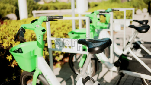 Video - Cannes, France - October 13, 2025: Close up of green electric bicycles parked in a sunny city area