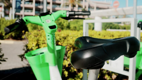 Video - Close up of a green electric bicycle with modern design, parked outdoors under natural light