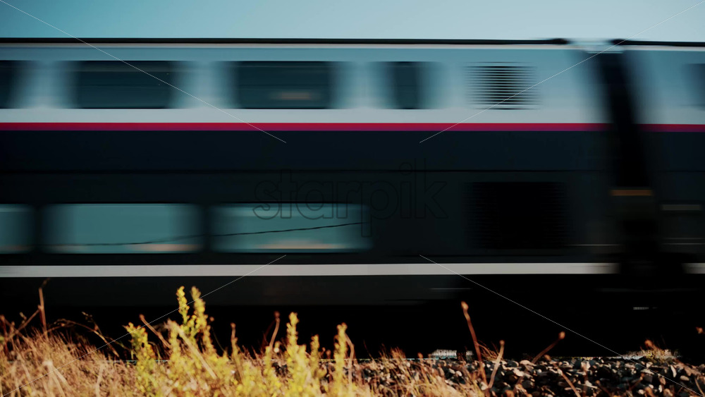 Video - Cannes, France - October 13, 2025: High speed white train passing quickly through rural landscape under blue sky