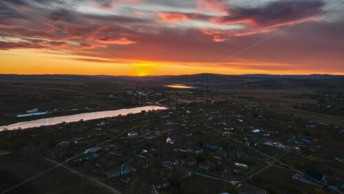 Video – Aerial drone view of a Moldovan village and winding river under a colorful sunset sky time lapse - Starpik Stock
