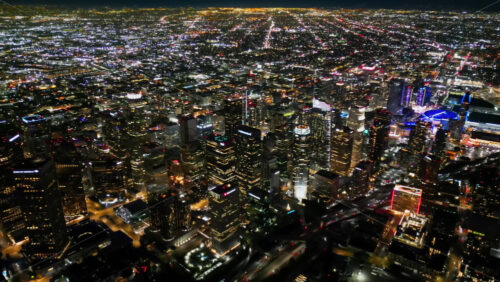 Video – Aerial drone view of the downtown Los Angeles skyline featuring bright skyscrapers and busy streets glowing under city lights - Starpik Stock