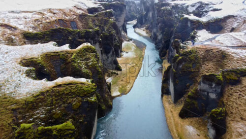 Video – Aerial drone view of the famous Fjaorargljufur Canyon in Iceland, showing the winding river flowing between steep moss covered cliffs - Starpik Stock