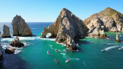 Video – Aerial drone view of the majestic Arch and surrounding cliffs of Cabo San Lucas under clear blue skies - Starpik Stock