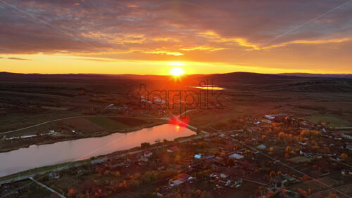 Video - Aerial drone view of a Moldovan village near a calm river at sunset