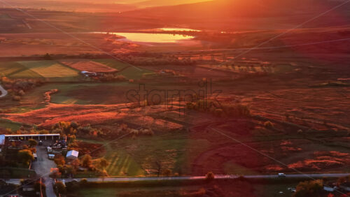 Video - Aerial drone view of a car driving along a countryside road in Moldova during golden hour