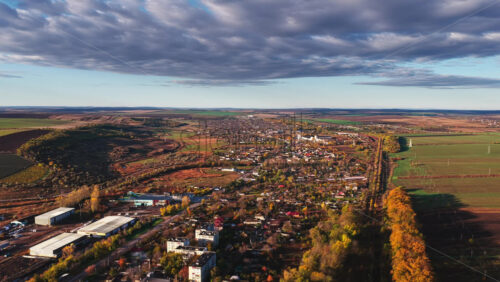 Video - Aerial drone view of a small Moldovan town surrounded by vast farmlands and hills