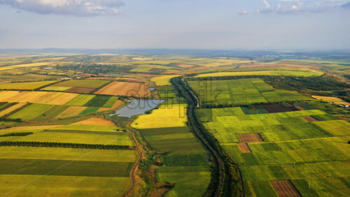 Video - Aerial drone view of a quiet Moldovan countryside with a winding river dividing green and yellow fields