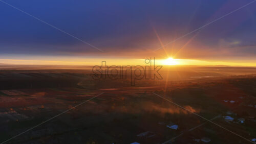 Video - Aerial drone view of sunrise illuminating vast Moldovan farmland