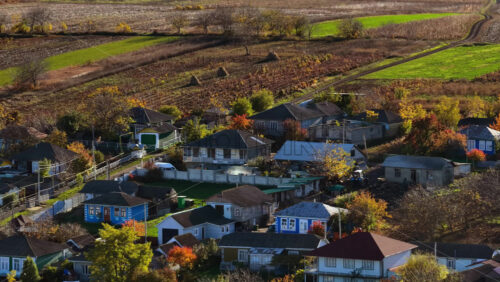 Video - Aerial drone view of a long village road running through Moldovan farmland and traditional homes