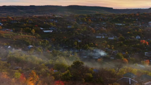 Video - Aerial drone view of smoke rising from farmlands in Moldova at golden hour
