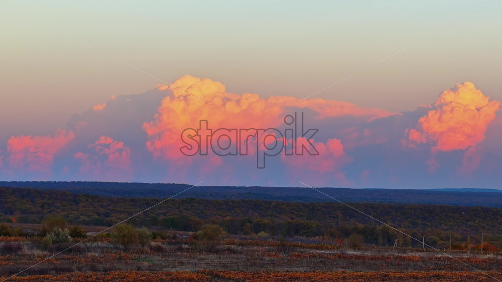 Video - Aerial drone view of soft pink clouds above autumn vineyards and fields in rural Moldova