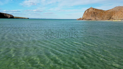 Video - Aerial drone view of the calm turquoise sea and rocky coastline of Baja California, Mexico