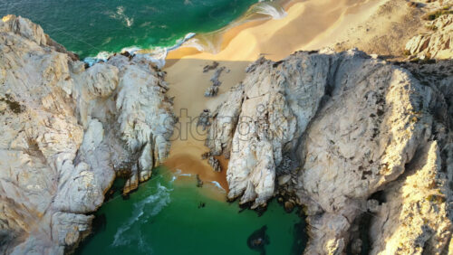 Video - Aerial drone view of waves breaking along a pristine stretch of golden sand in Cabo San Lucas