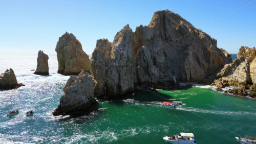 Video - Aerial drone view of the majestic Arch and surrounding cliffs of Cabo San Lucas under clear blue skies