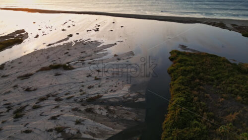 Video - Aerial drone view of a peaceful river winding through a lush palm oasis in Baja California Sur