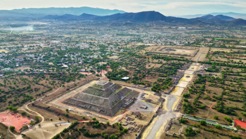 Video - Aerial drone view of the ancient Teotihuacan pyramids with the surrounding Mexican town and mountain landscape
