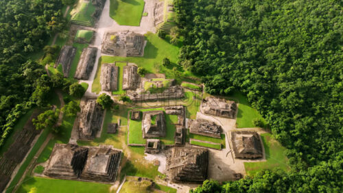 Video - Aerial drone view of ancient Mayan ruins hidden within a dense green jungle