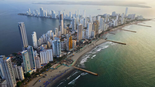 Video - Aerial drone view of Cartagena's coastal skyline with beaches, residential towers, and the shimmering Caribbean Sea in the background