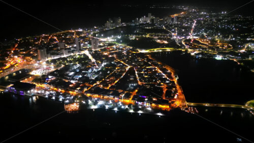 Video - Aerial drone view of Cartagena at night showing both the colonial old town and the modern skyline glowing with orange and white lights