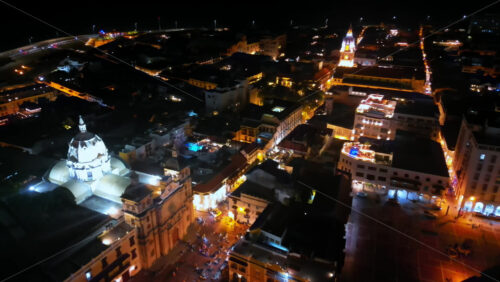 Video - Aerial drone view of Cartagena's illuminated cathedral and surrounding colonial buildings at night