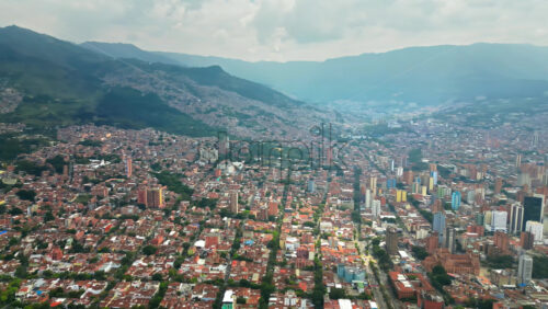 Video - Aerial drone view of of Medellin, Colombia, showing the dense urban area surrounded by green mountains in slow motion