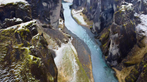 Video - Aerial drone view looking straight down at the turquoise river winding through the dramatic cliffs of Fjaorargljufur Canyon