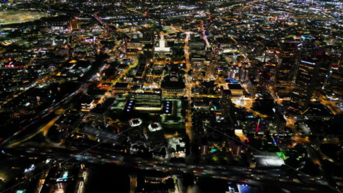 Video - Aerial drone view of Los Angeles seen from high altitude, showing a vast urban landscape full of glowing lights, roads, and buildings stretching into the distance