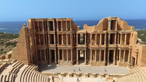 Video - Aerial drone view of the magnificent Roman Theatre of Sabratha, highlighting the detailed columns, arches, and stage area of the ancient structure