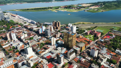 Video - Aerial drone view of a Patagonian city with modern buildings, historical architecture, and a wide river flowing through the landscape