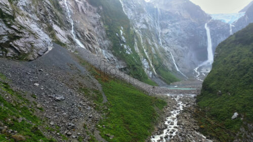 Video - Aerial drone view of a glacier melt river with intricate channels flowing into a turquoise lake
