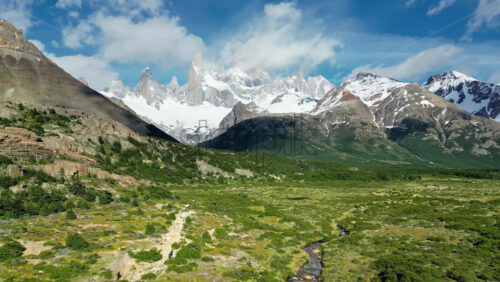 Video - Aerial drone view of Mount Fitz Roy and surrounding peaks under a clear blue sky