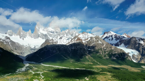 Video - Aerial drone view of Mount Fitz Roy and surrounding peaks under a clear blue sky