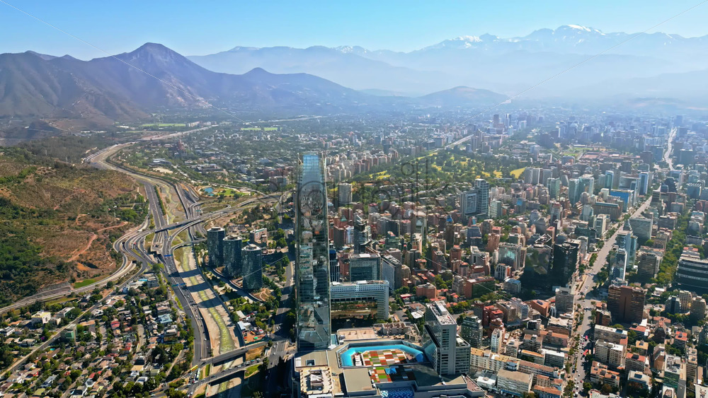 Video - Aerial drone view the city's modern district, showing highways and the tallest building in Latin America with mountains behind
