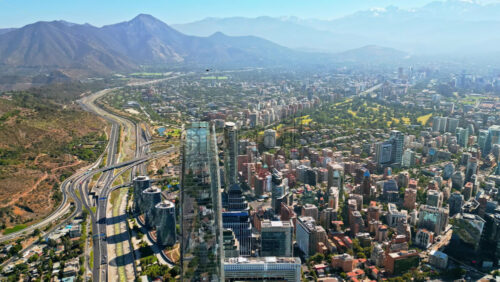 Video - Aerial drone view the city's modern district, showing highways and the tallest building in Latin America with mountains behind
