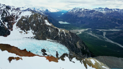 Video - Aerial drone view of the hanging glacier of Queulat with multiple cascading waterfalls and turquoise pools below in slow motion