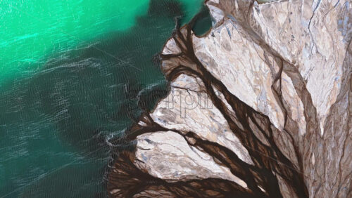 Video – Aerial drone view a mineral lake with bright turquoise water meeting textured white sediment - Starpik Stock