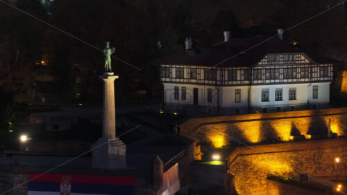 Video – Aerial drone view of Belgrade’s iconic Victor Monument, beautifully lit against the fortress and old architecture at night - Starpik Stock