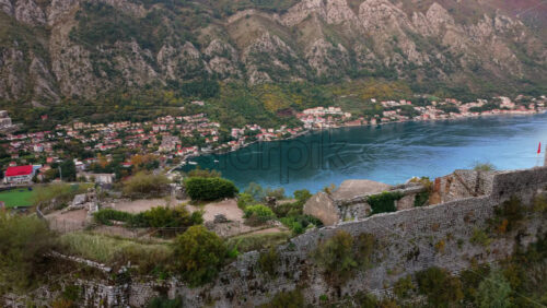 Video – Aerial drone view of Kotor’s ancient fortress walls perched on the mountainside, overlooking the town and the bay far below - Starpik Stock