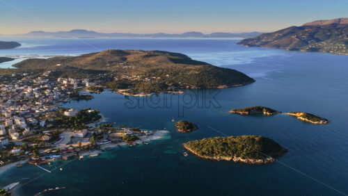 Video – Aerial drone view of Ksamil town, it’s dense cluster of hotels and houses, and the iconic bright blue bays with floating platforms and beach clubs - Starpik Stock