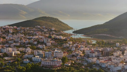 Video – Aerial drone view of Ksamil’s hilltop neighborhoods, with layered houses overlooking small coves and forested patches leading to the sea - Starpik Stock