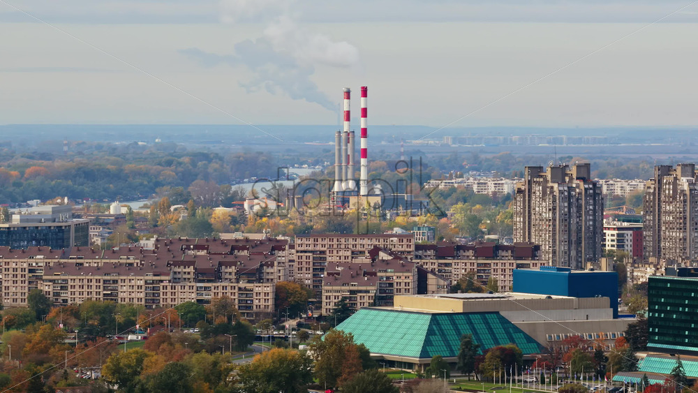 Video – Aerial drone view of Novi Beograd, Serbia, highlighting large residential block buildings and the distinctive chimneys of the Novi Beograd heating plant in the distance - Starpik Stock