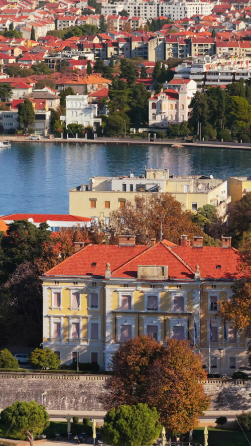 Video – Aerial drone view of Primosten’s waterfront lined with cafes and restaurants, backed by charming old stone houses with colorful shutters. Vertical - Starpik Stock