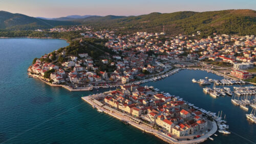 Video – Aerial drone view of Tribunj, with marinas full of boats and warm sunlight reflecting across the sea. Croatia - Starpik Stock