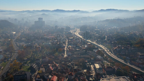 Video – Aerial drone view of Tuzla city blanketed in fog with mountain silhouettes in the background. Boznia and Herzegovina - Starpik Stock