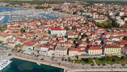 Video – Aerial drone view of a coastal town with a large white church at its center. Biograd na Moru, Croatia - Starpik Stock
