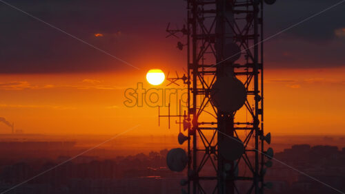 Video – Aerial drone view of a large telecommunications tower set against an intense orange sunset over Belgrade, Serbi - Starpik Stock