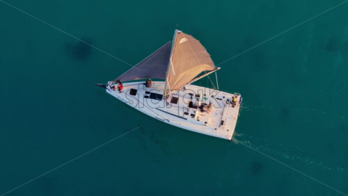 Video – Aerial drone view of a white sailboat gliding smoothly over calm turquoise water - Starpik Stock