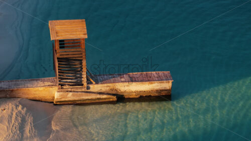 Video – Aerial drone view of an old wooden pier and lookout structure on Ksamil Beach, with clear turquoise waters and soft sand textures - Starpik Stock