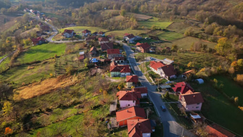 Video – Aerial drone view of an organized residential area with neat houses, terracotta roofs, and green agricultural plots in Bosnia and Herzegovina - Starpik Stock