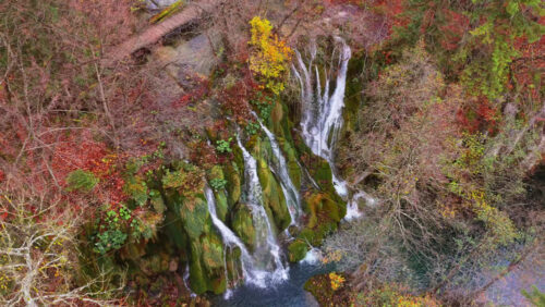 Video – Aerial drone view of cascading waterfalls flowing over moss covered cliffs and lush vegetation in Plitvice Lakes National Park, Croatia - Starpik Stock
